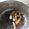 Ein silberner Aschenbecher mit Zigarettenstummeln