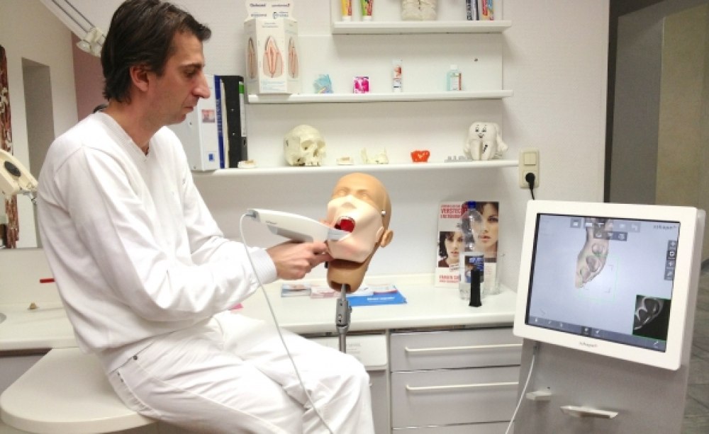 Dr.-medic stom. (RO) Christian Schäfer zeigt am Dummy die Arbeit mit dem Intraoralscanner 3Shape Trios. Dr.-medic stom. (RO) Christian Schäfer