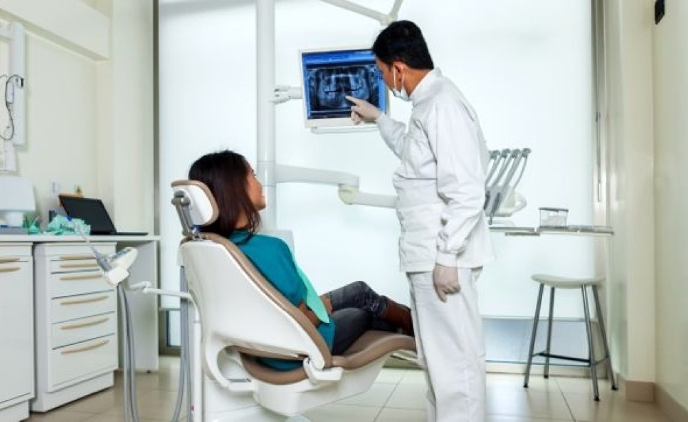 Zahnarzt berät Patientin am Stuhl