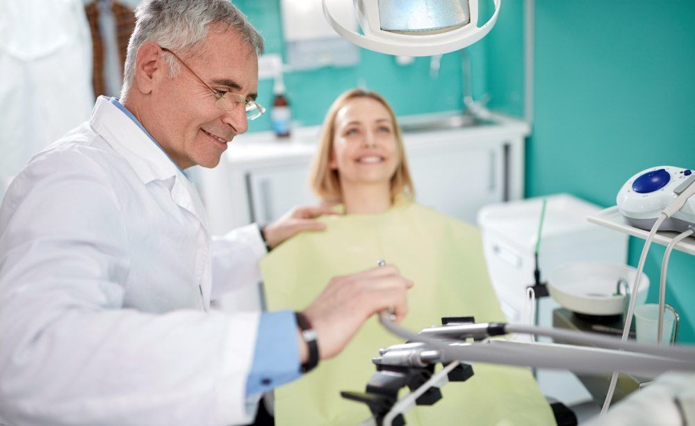 Älterer Zahnarzt mit Patientin