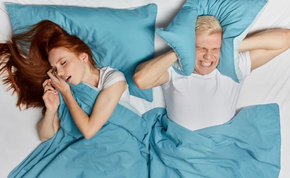Mann und Frau im Bett, sie schnarcht