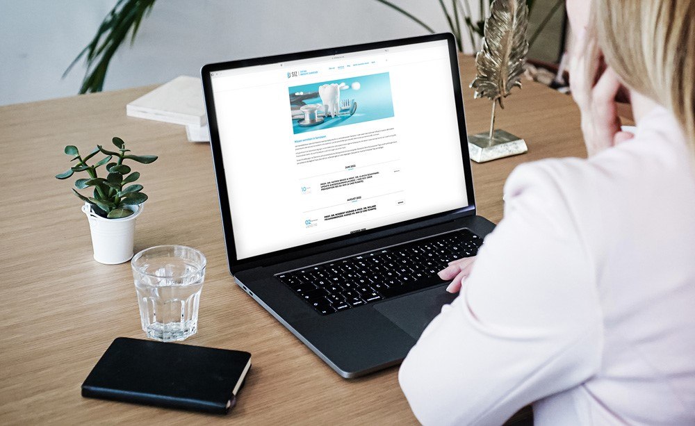 SIZ: Seminartermine 2022 Frau von hinten Sitz an Laptop an Schreibtisch