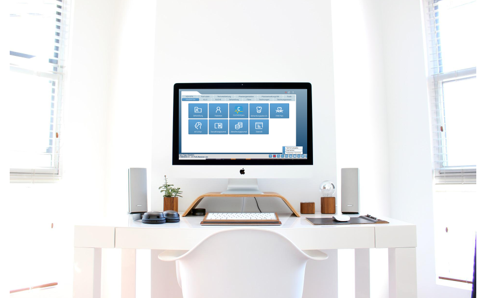 Die Digitalisierung ist für Zahnarztpraxen eine Chance Frontalblick auf Arbeitsplatz mit großem Monitor