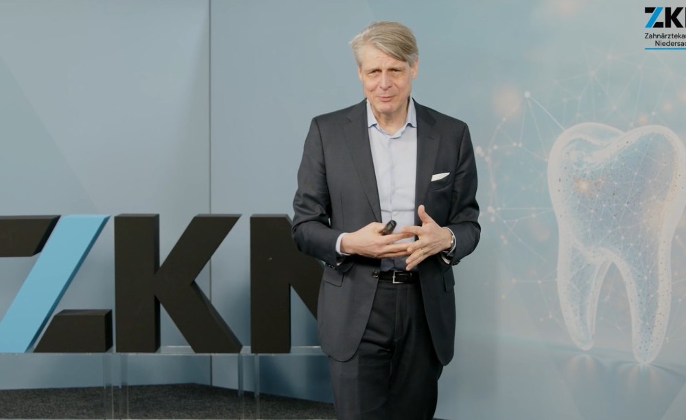 Kongressleiter Prof. Dr. Dr. h.c. Thomas Attin (Zürich) ging auf das erhöhte Erosions-Risiko und das trainingsabhängige Kariesrisiko von Ausdauersprotlern ein. Mann mit Mikrofon auf einer Bühne