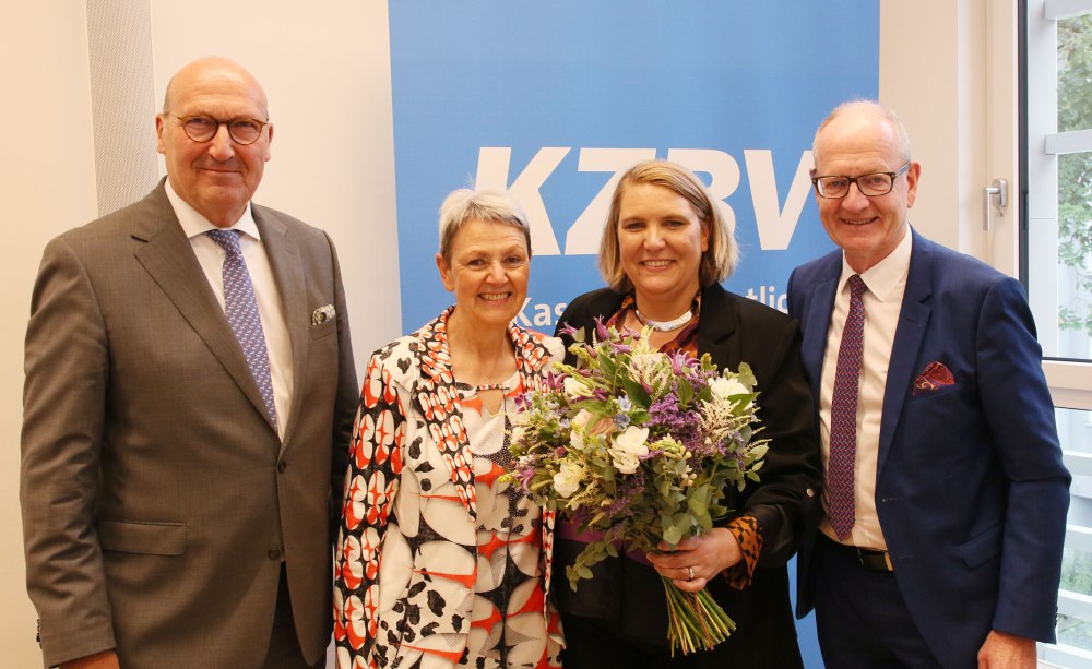 zwei Männer und zwei Frauen stehen nebeneinander vor einem KZBV-Schild