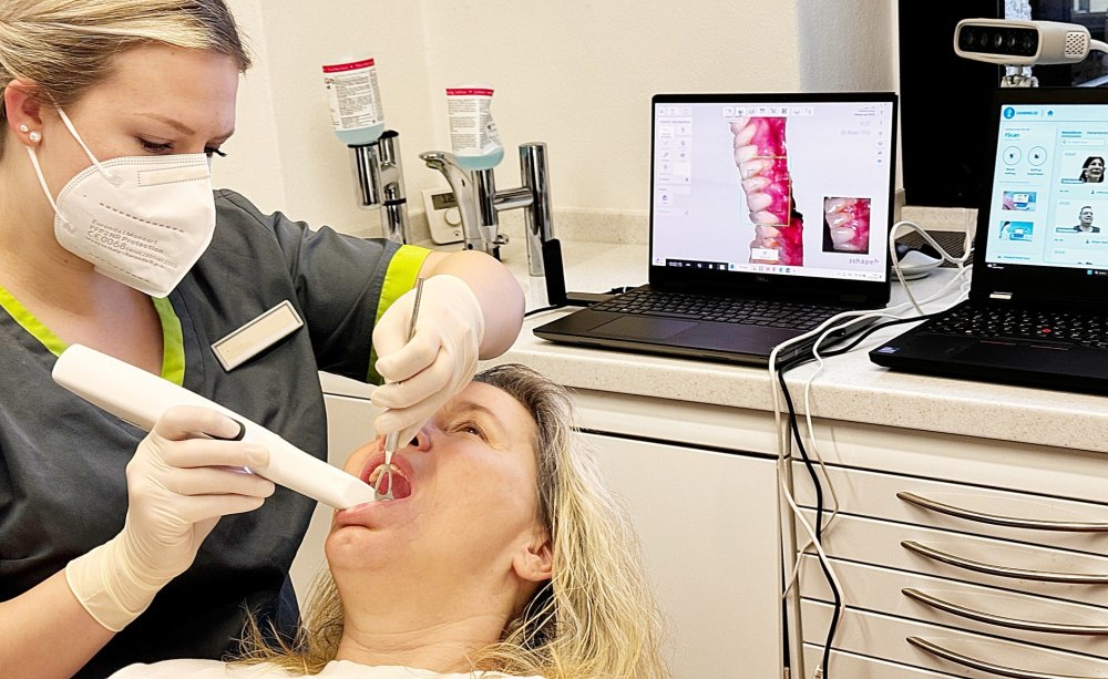 Der Intraoralscan ist Ausgangsmedium für viele digitalisierte Prozesse in Praxis und ZT-Labor. Frau mit Intraoralsscanner mit einer Patientin