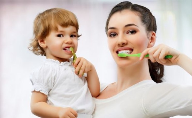 Mutter mit Kind putzen Zähne