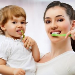 Mutter mit Kind putzt Zähne