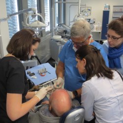 Dr: Ady Palti mit Teilnehmern des Curriculums Minimal-Invasive Implantologie während einer Live-OP.