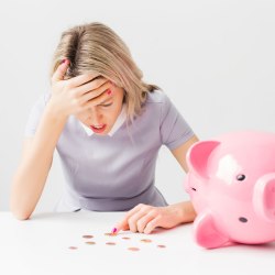 Frau zählt Geld aus dem Sparschwein