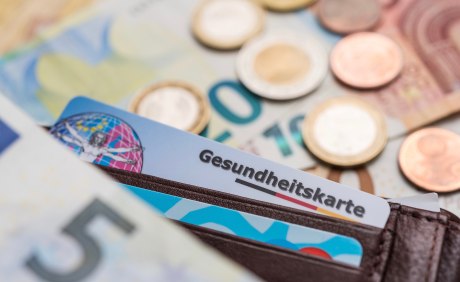 Euroscheine und -münzen und eine Gesundheitskarte in einem Portemonaie 
