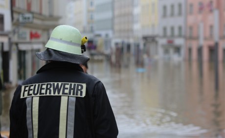 Ein Feuerwehrmann blickt auf das Hochwasser