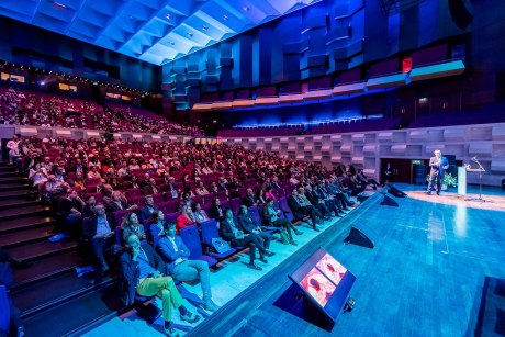 Großes Auditorium mit Sprecher auf der Bühne