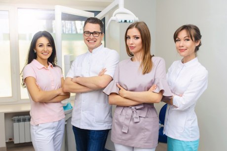 Gruppe aus drei Frauen und einem Mann in Zahnarztpraxis