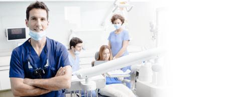 Zahnarzt schaut in die Kamera im Hintergrund  Patientin und Arzt/Ärztin