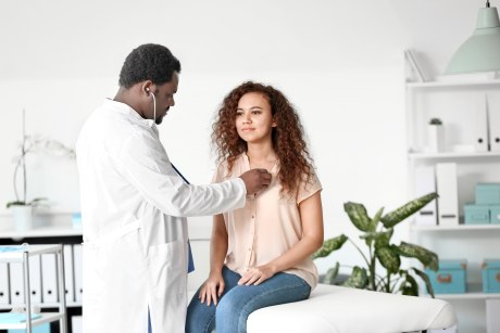 Arzt untersucht eine junge Frau