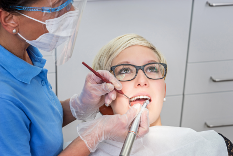 Blonde Frau bekommt Zahmnreinigung von einer Zahnärztin