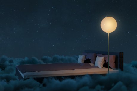 Bett mit Stehlampe auf Wolken schwebend
