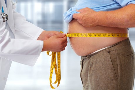 Arzt misst Bauchumfang eines dicken Mannes