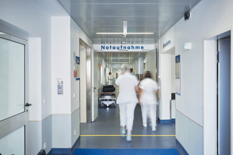 Eingang zu einer Notaufnahme im Krankenhaus mit verschwommenen Personen