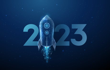 Ein Bild, das einen dunkelblauen, sternenbesetzten Fonds zeigt, vor dem die Zahlen 2023 schweben. Die Null wird durch eine startende Rakete symbolisiert.