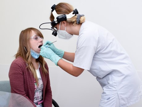 Zahnärztin kontrolliert Zähne bei einer Patienten mit halbseitiger Gesichtslähmung