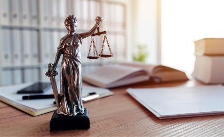 Statue der Justizia auf dem Schreibtisch