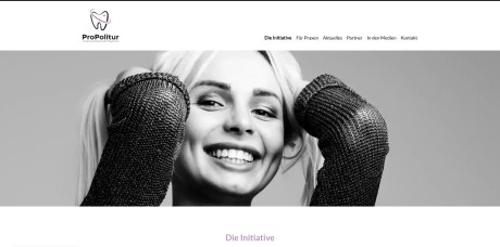 Website mit Schwarzweiß-Bild einer Frau, die mit einem Lächeln ihr schönes Gebiss zeigt