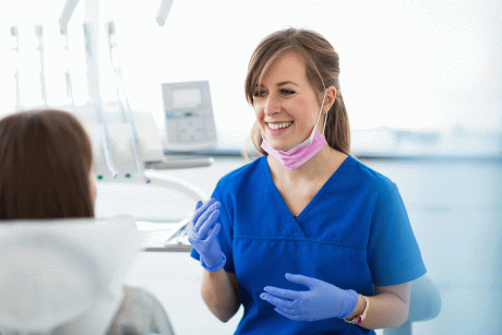 Zahnärztin berät Patienten auf Stuhl - Mehr Frauen in Ambulanz