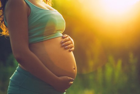Foto einer schwangeren Frau, Fokus auf Bauch - Junge Ärztinnen fürchten um Beruf in Schwangerschaft