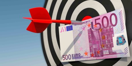 Ein roter Pfeil durchsticht auf einerr Zielscheibe einen 500-Euro-Schein