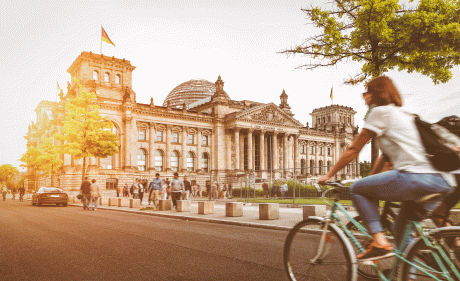 Radfahrerin vor deutschem Bundestag im Sonnenuntergang