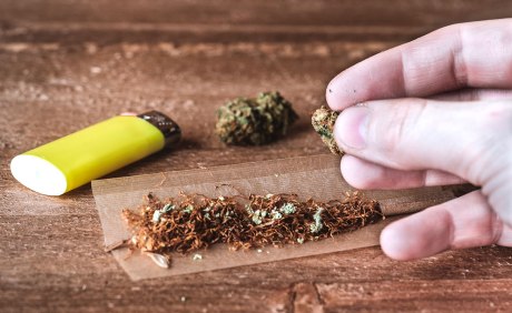 Bild eines langen Zigarettenblättchens und einer Tabakmischung mit Marihuana