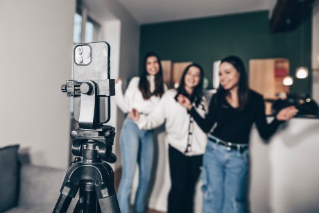 Drei junge Frauen vor Handykamera auf Stativ