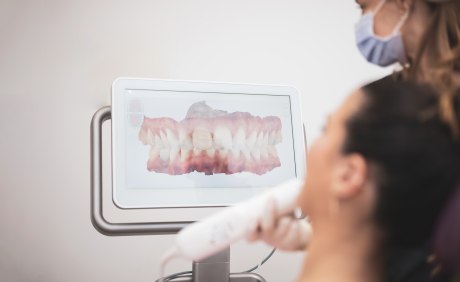 Zahnarzt scannt Gebiss einer Patientin mithilfe eines Intraoralscanners
