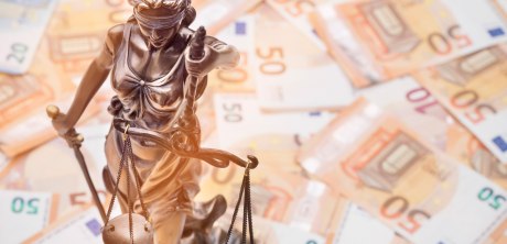 Lady Justice steht vor auf dem Hintergrund ausgelegten fünfzig Euro Scheinen