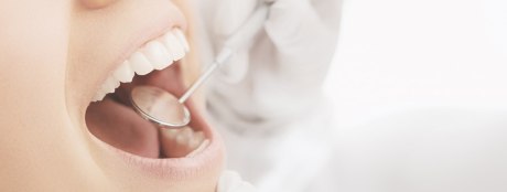 Geöffneter Mund mit einem zahnmedizinischem Instrument