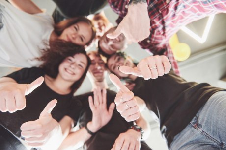 Glückliche gruppe von freunden mit ihren händen zusammen in der mitte