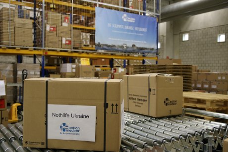 Pakete mit Aufschrift "Nothilfe Ukraine" auf Laufband