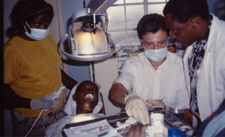 Dr. Schinkel mit Helfern bei der Behandlung eines Patienten auf Behandlungsstuhl 