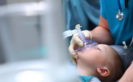kleiner Junge schlafend mit Anästhesiemaske vor dem Gesicht