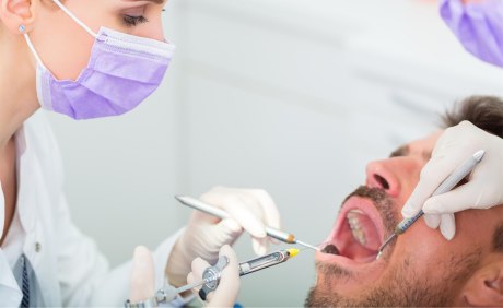 Behandlungssituation beim Zahnarzt mit Mann mit geöffnetem Mund