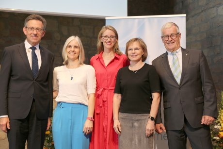 Zwei Männer und drei Frauen stehen nebeneinander und schauen in die Kamera