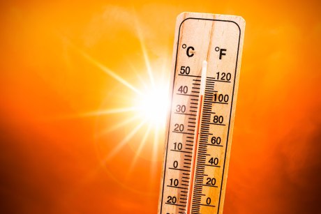 Thermometer zeigt über 40 Grad Celsius an, im Hintergrund grell die Sonne