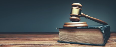 Gavel (Richterhammer) liegt auf Resonanzblock, darunter ein Buch