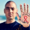 Nahaufnahme einer Hand mit aufgemalter AIDS-Schleife und positiven Worten