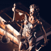 Goldene Justizia-Figur vor Bücherstapel