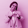 Young business mixed race woman isolated on pink background smiling and showing a heart shape with hands.