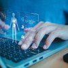 Mensch am Notebook, Hände auf der Tastatur, virtuelle Anmutung einer Patientenakte