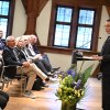 sitzendes Publikum, festlich geschmückter Raum, ein Mann spricht am Podium